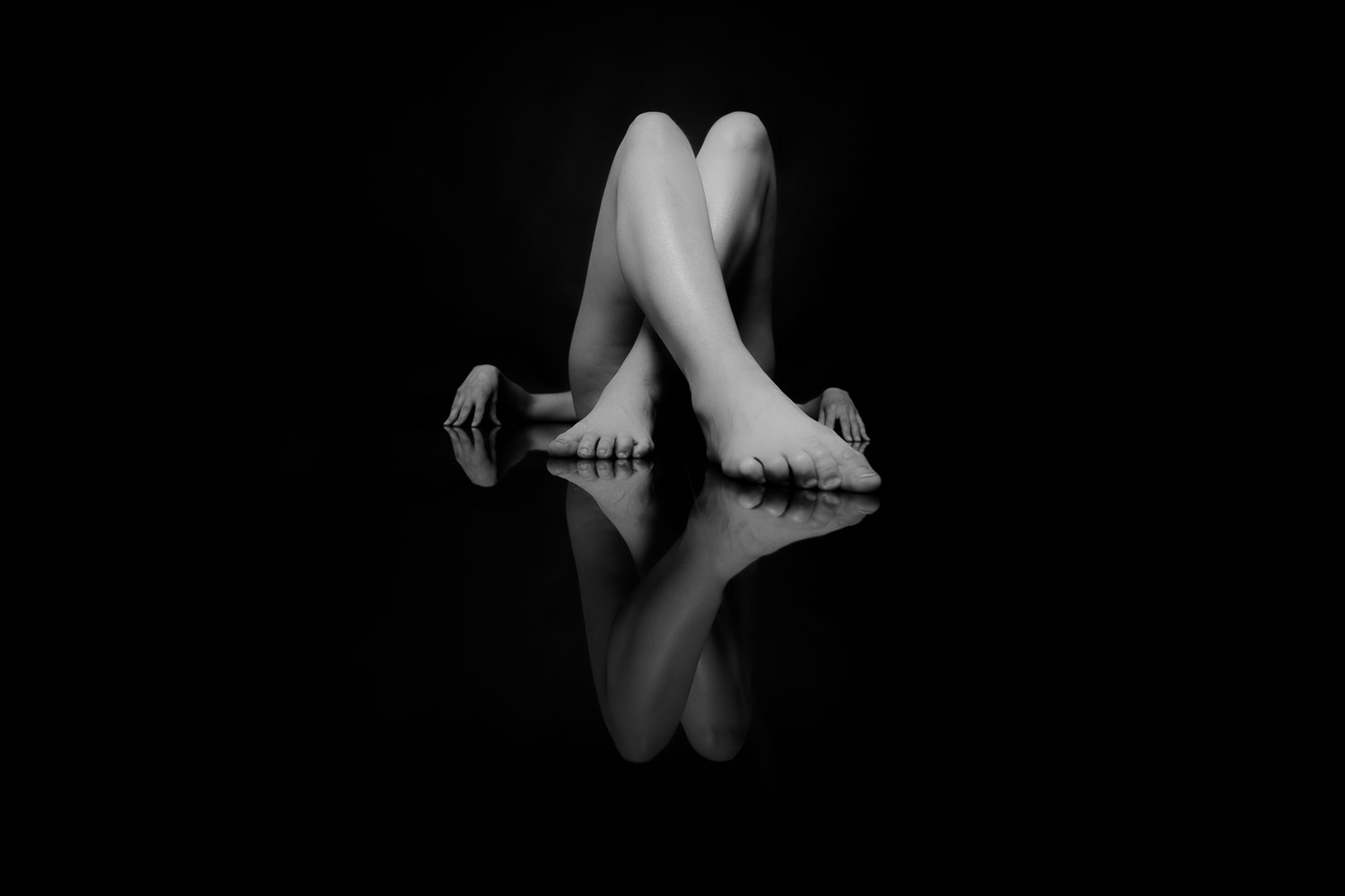 Die Beine einer Frau, der Untergrund spiegelt sich.