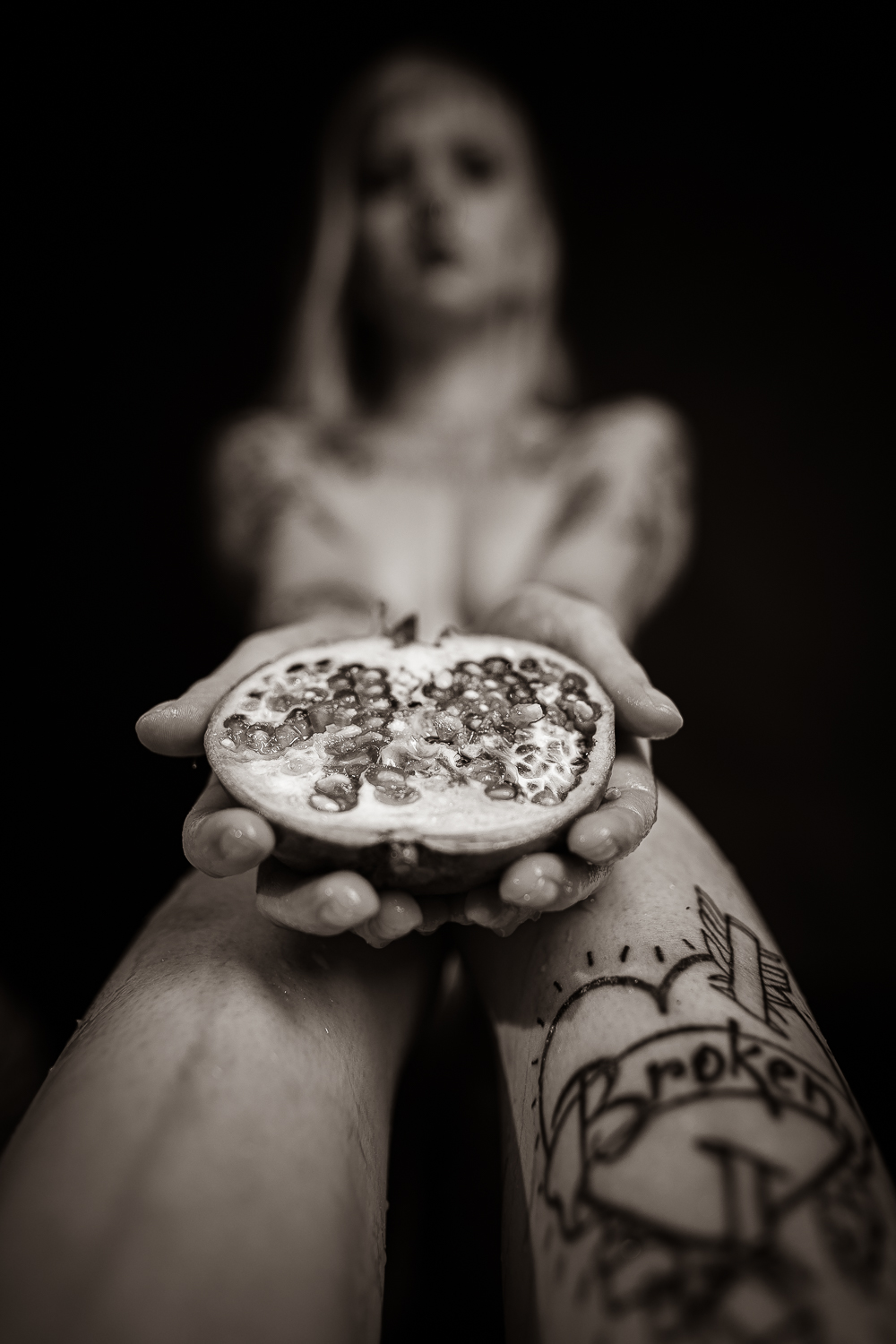 Eine Frau, die einen Granatapfel in der Hand hält.